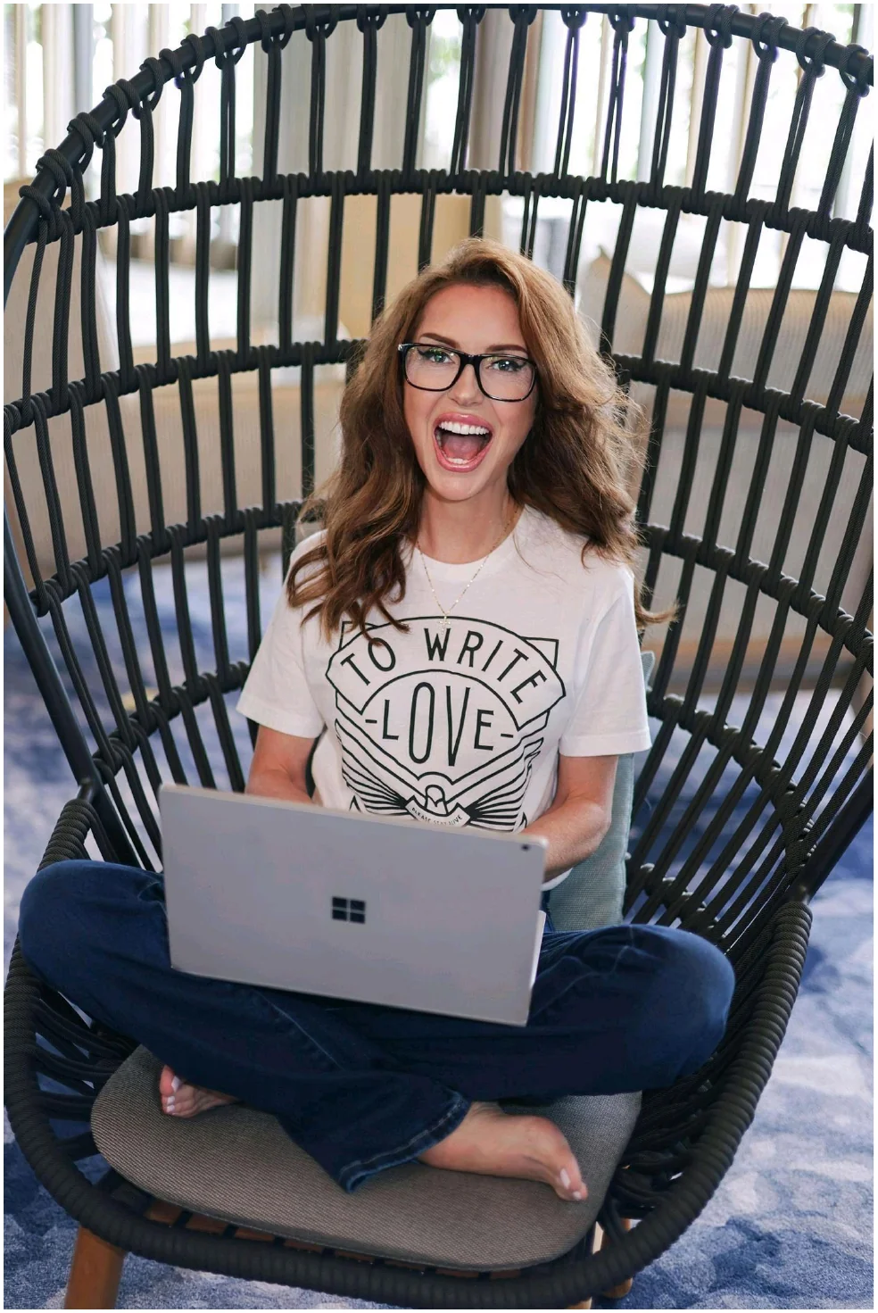 Amanda Kasmira “Kazzy” Cryer in egg chair with laptop — editorial portrait
